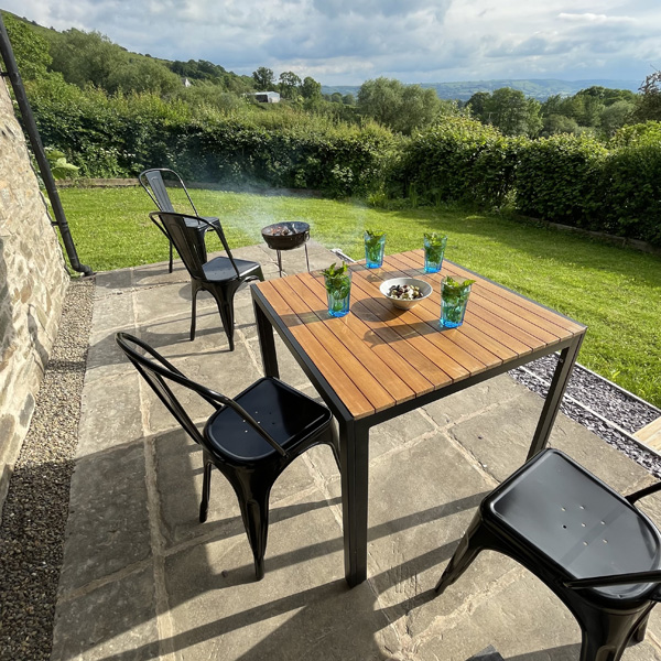 Relax with a drink by the fire pit in the garden overlooking the Shropshire hills